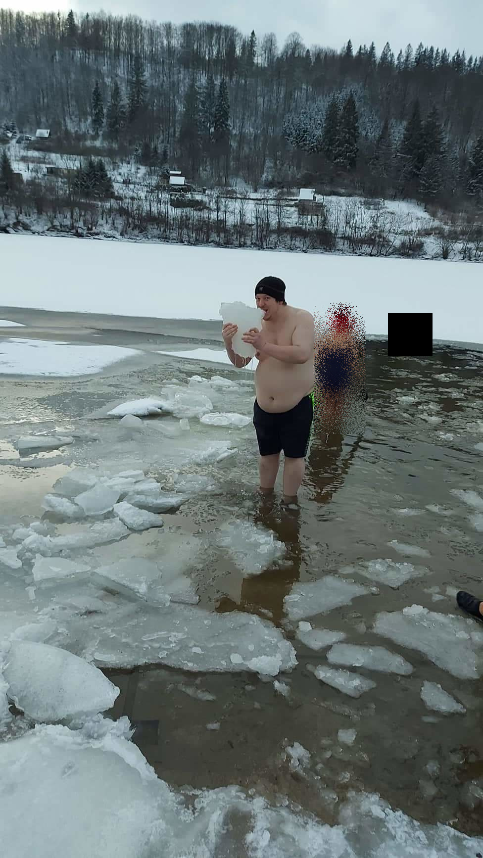 Jozef Môstka po pás v ľadovej vode zamrznutého jazera, v rukách drží kus ľadu — január 2021, prvé otužovanie.
