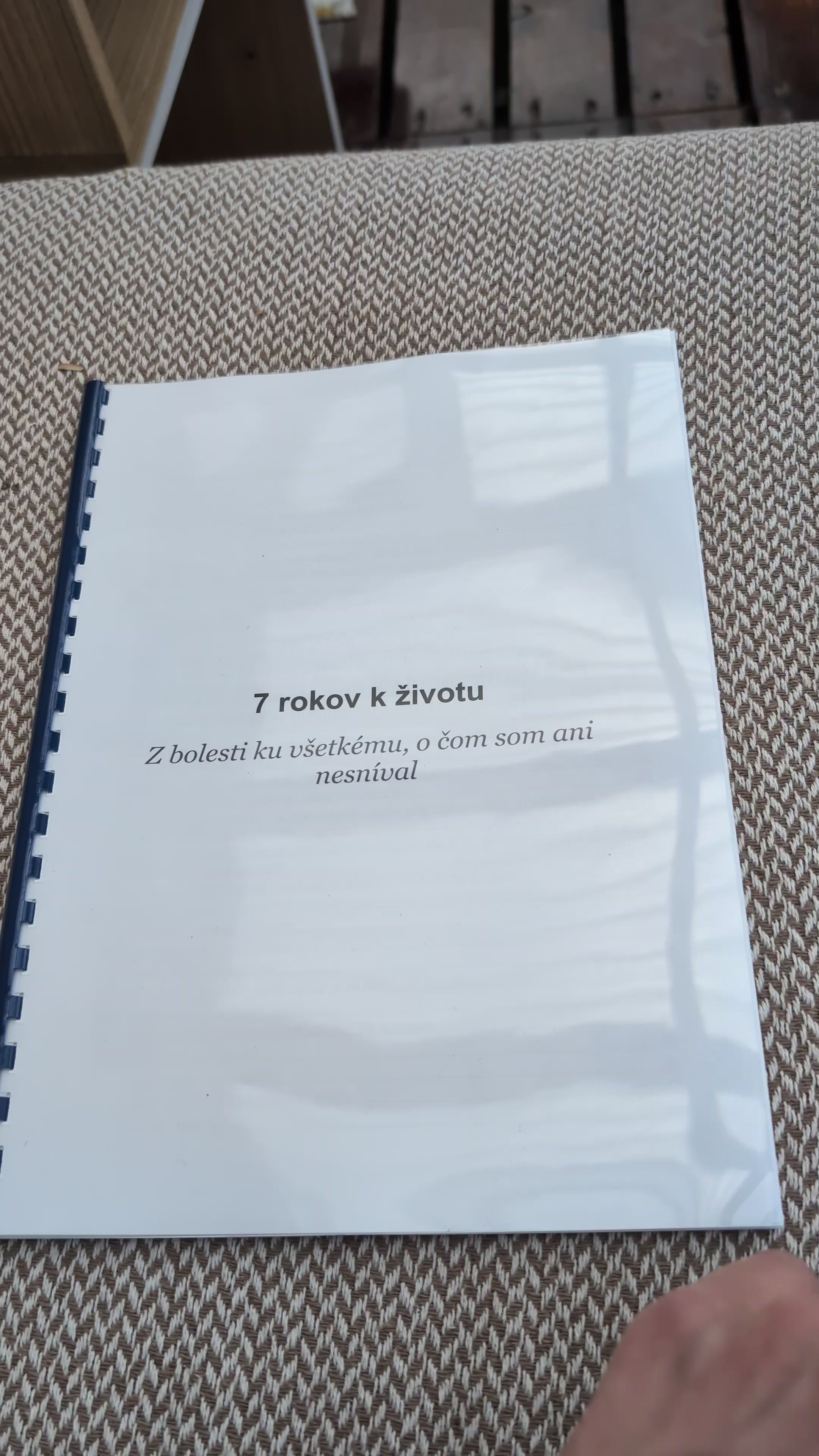 Vytlačený rukopis knihy 7 rokov k životu v hrebeňovej väzbe leží na sedačke, na titulnej strane je názov a podtitul Z bolesti ku všetkému, o čom som ani nesníval.